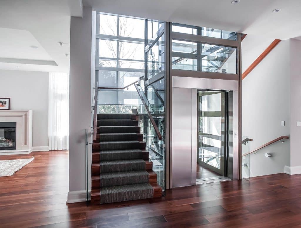 Glass elevator built into landing onto a luxury living area